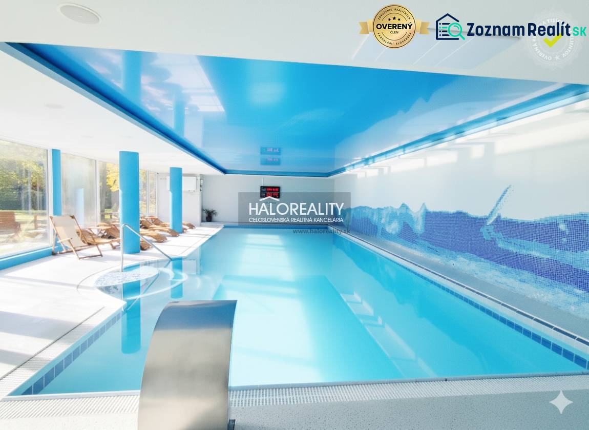 Bazén s modrými stropy a lehátky v interiérových gastro prostorech.