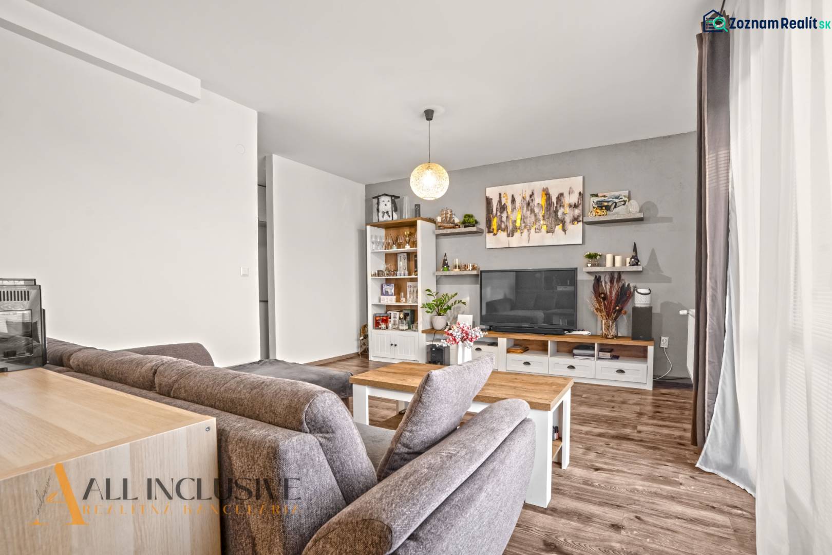 Obývací pokoj v 2-pokojovém bytě s podlahou s dřevěným dekorem, pohodlným sezením a dekoracemi.