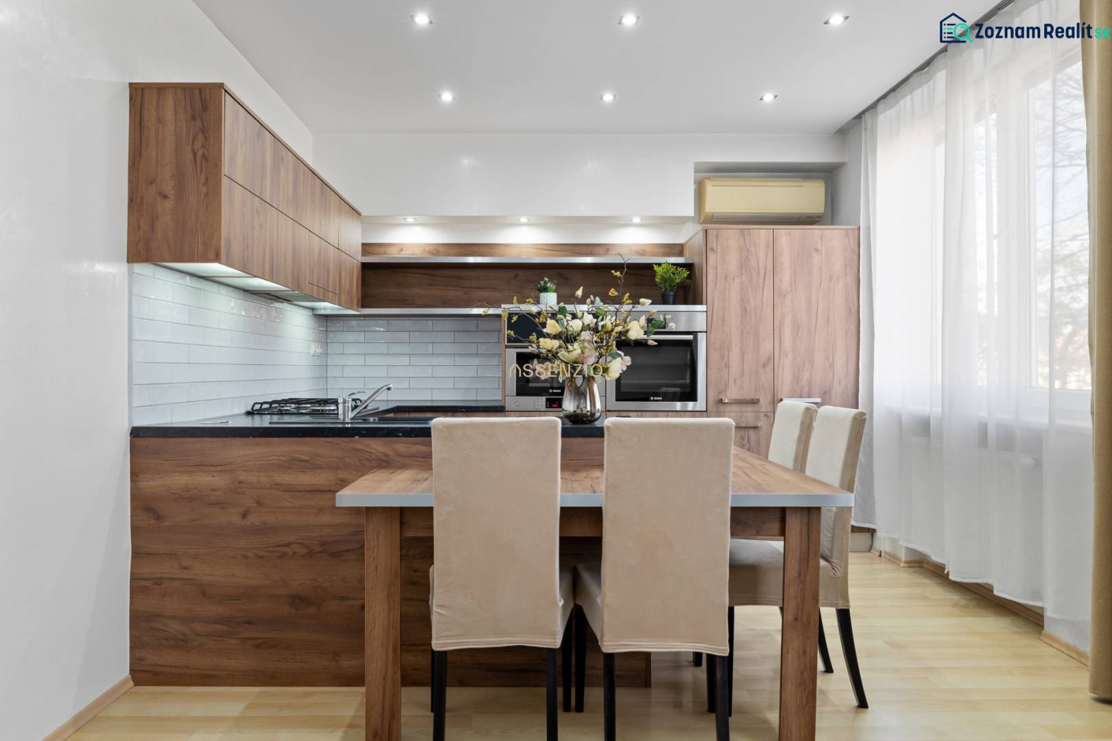 Kuchyně v 2-pokojovém bytě s dřevěným dekorem a světlým nábytkem.