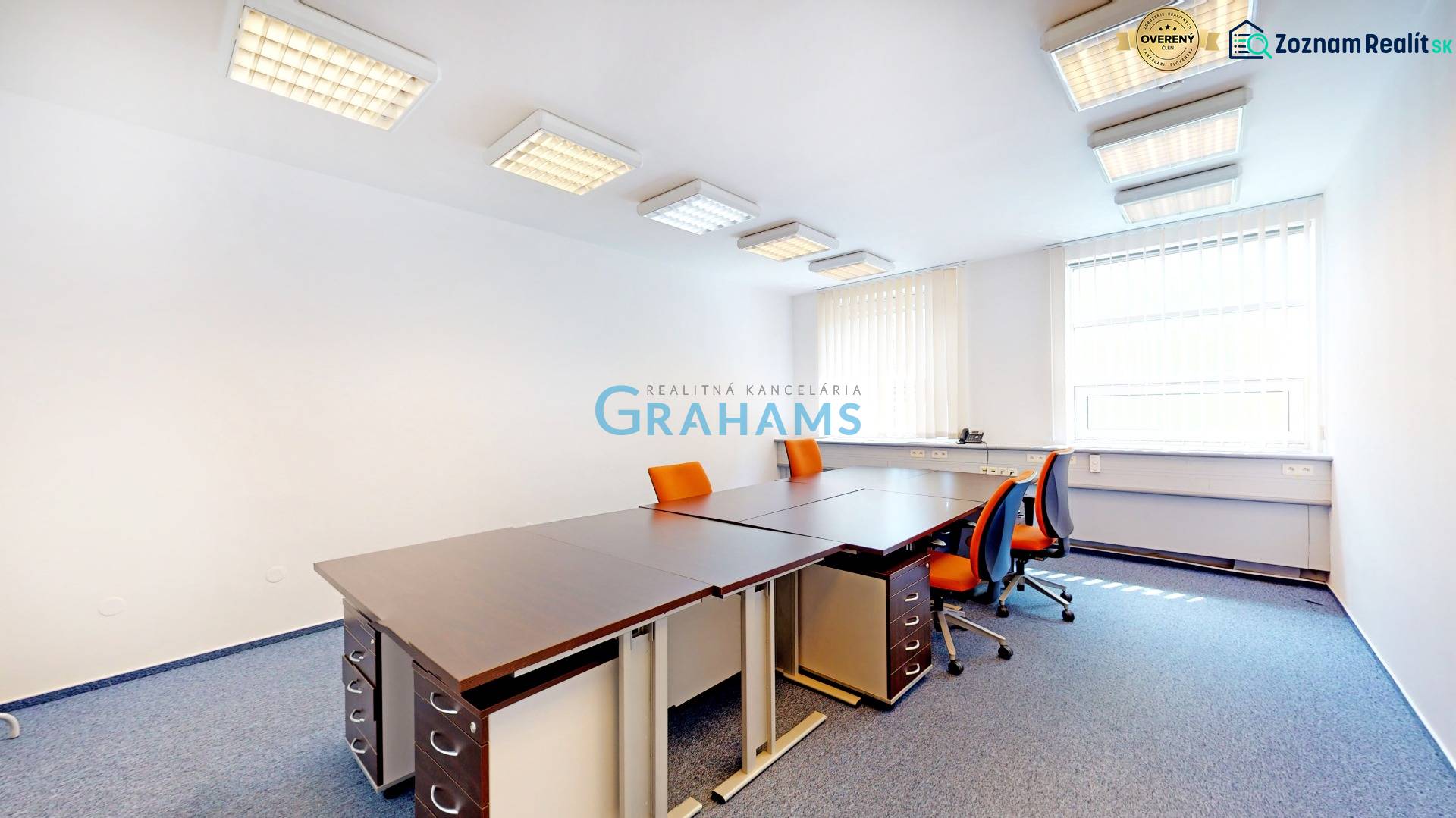 Kancelář s oranžovými židlemi a rohovým oknem, místnost vybavená závěsy.