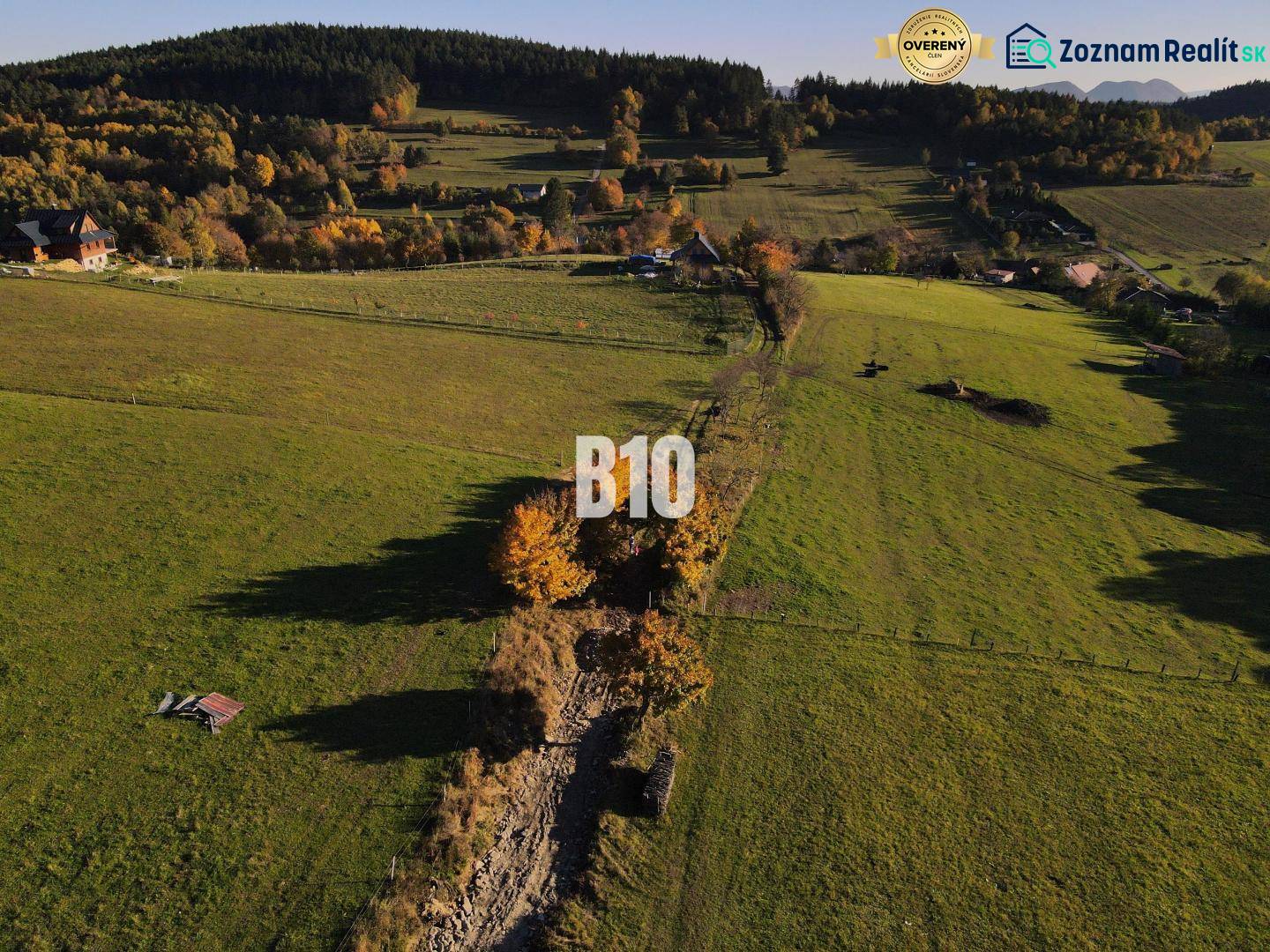 Zeleň a louky v Pozemcích - bydlení v Petrovicích, obklopené stromy a kopci.