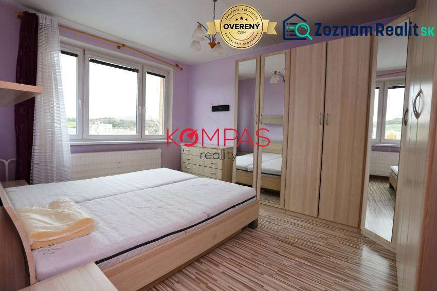 Světlá ložnice s podlahou s dřevěným dekorem v 3pokojovém bytě.