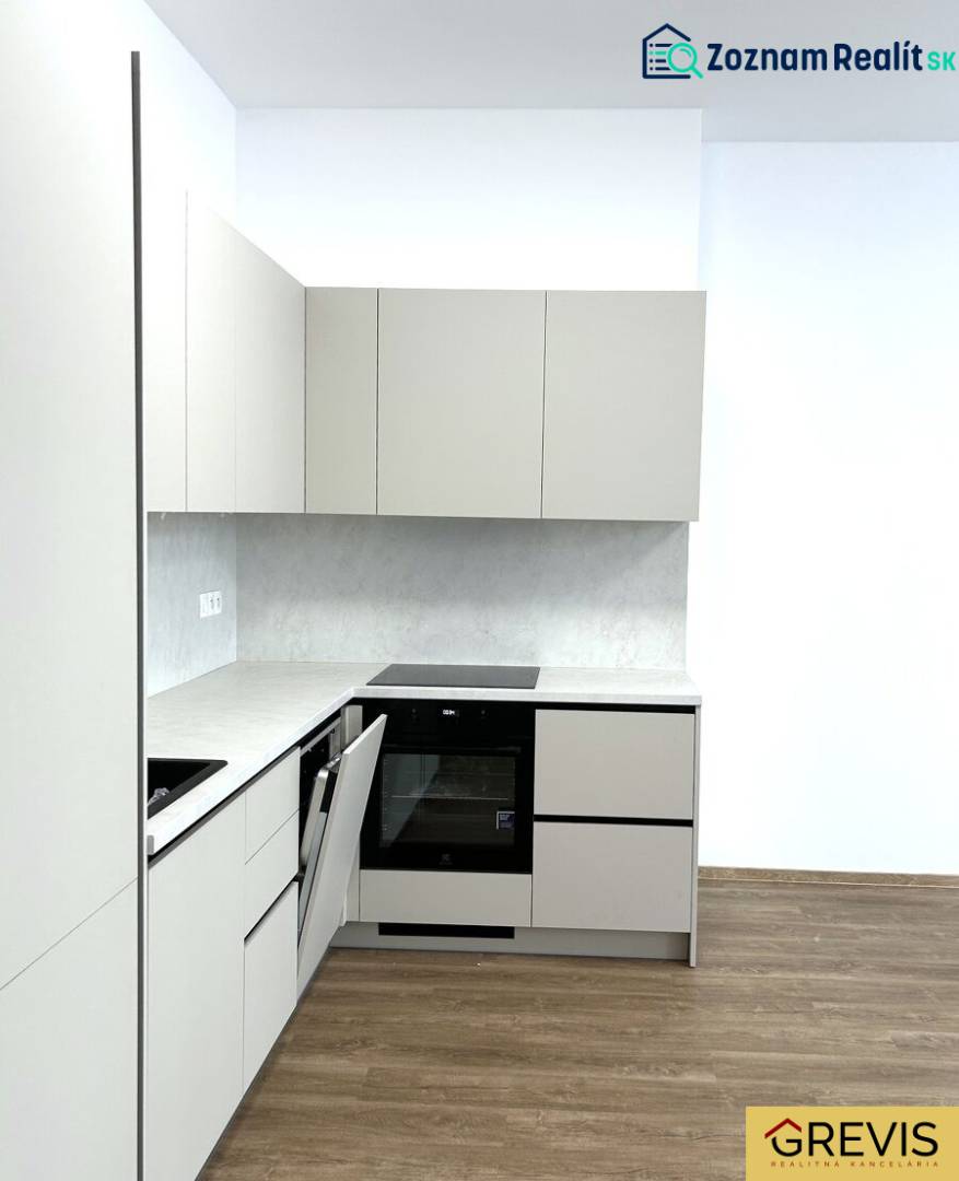 Kuchyně ve 4-pokojovém bytě s podlahou s dřevěným dekorem a bílými skříňkami.