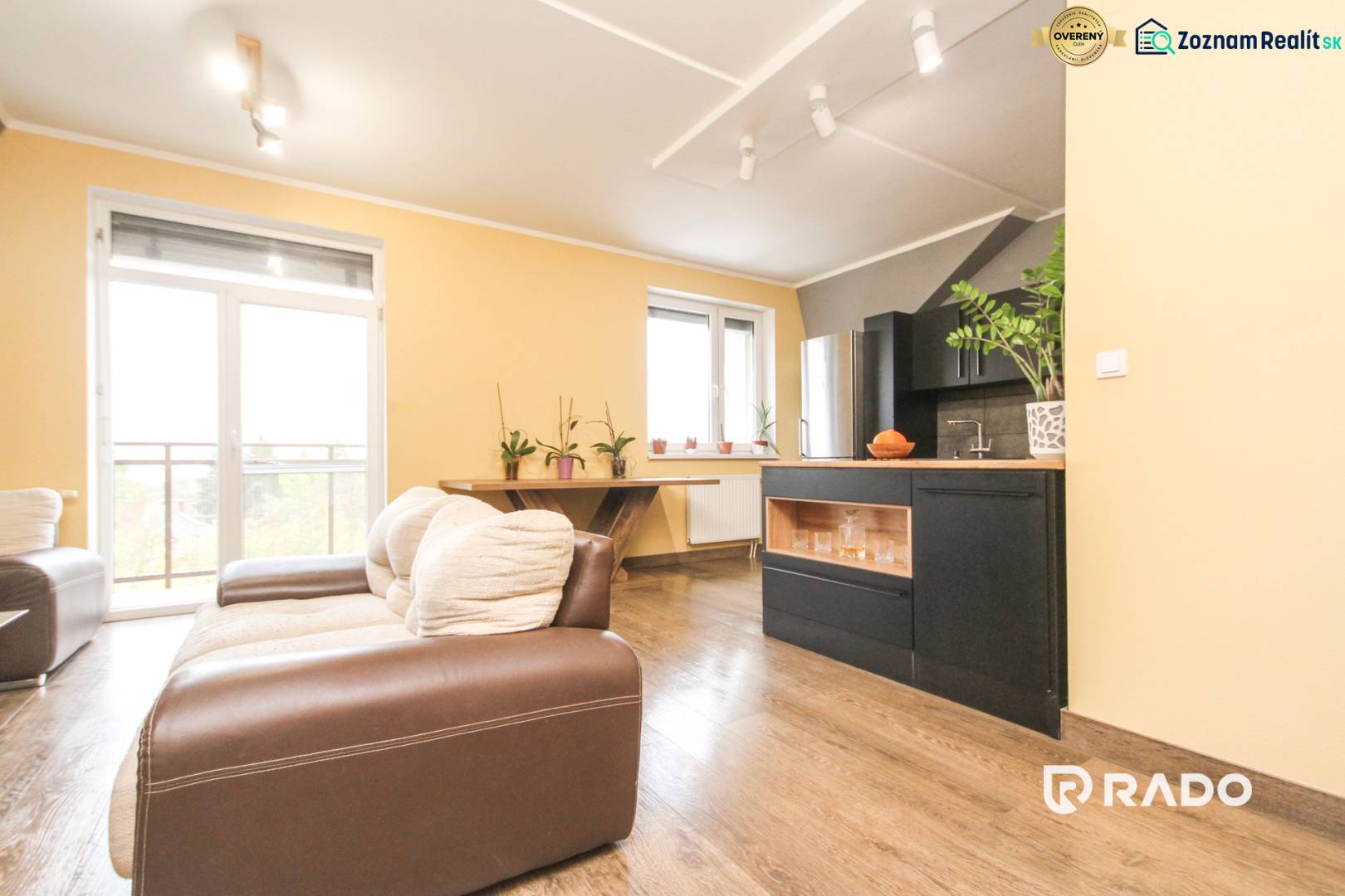 Obývací pokoj ve 4pokojovém bytě s podlahou s dřevěným dekorem a pohovkou.