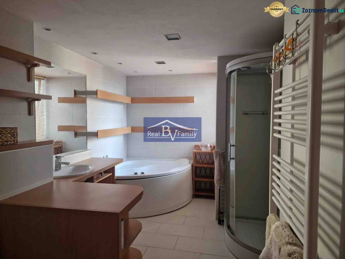 Koupelna v 2-pokojovém bytě, s vanou, sprchovým koutem a poličkami.