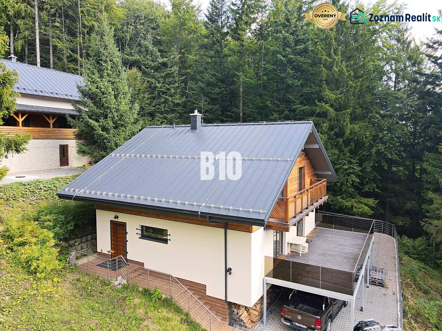 Chata v Terchové obklopená lesy s velkou terasou a parkovacím místem.