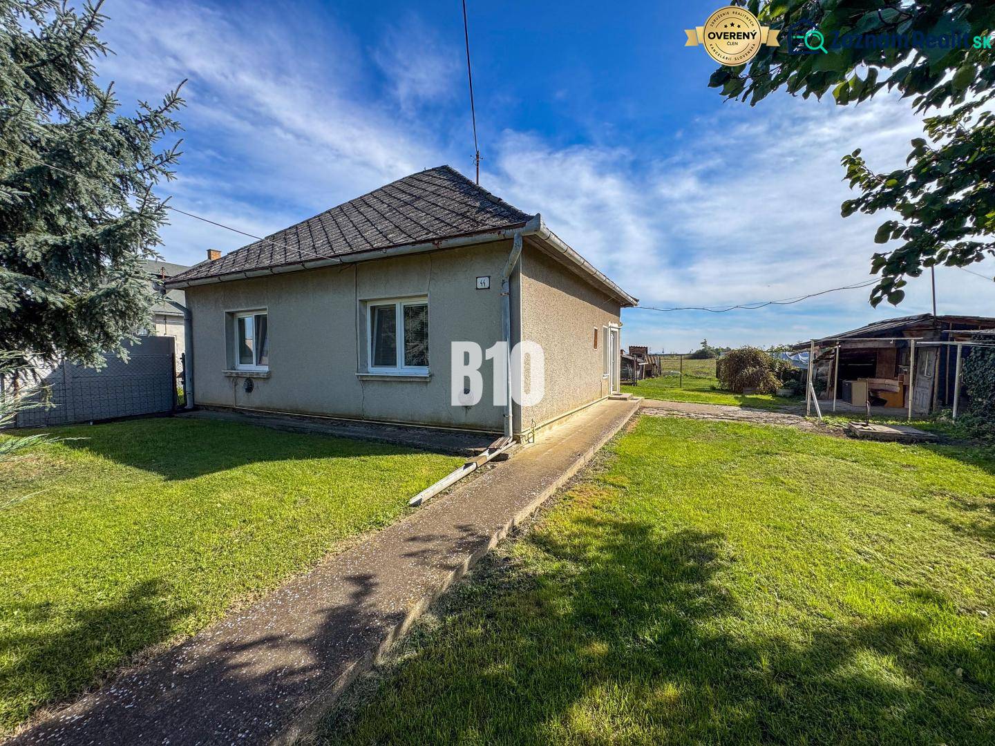 Rodinný dům v Ondrejovcích s travnatým dvorem pod modrou oblohou.
