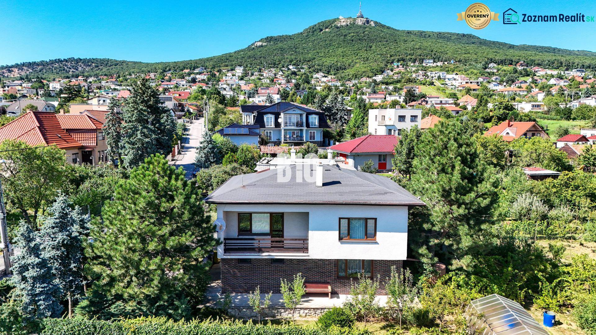 Rodinný dům na Kamenné ulici v Nitře obklopený zelení a dalšími domy.