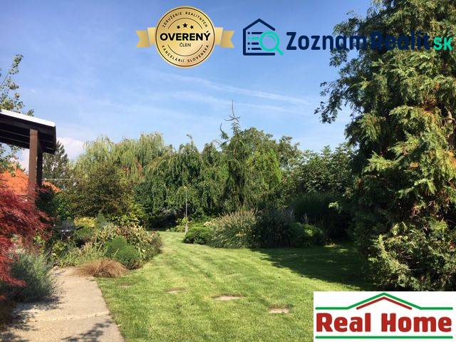 Zahrada u rodinného domu v Černé Vodě s bohatou výsadbou a udržovaným trávníkem.