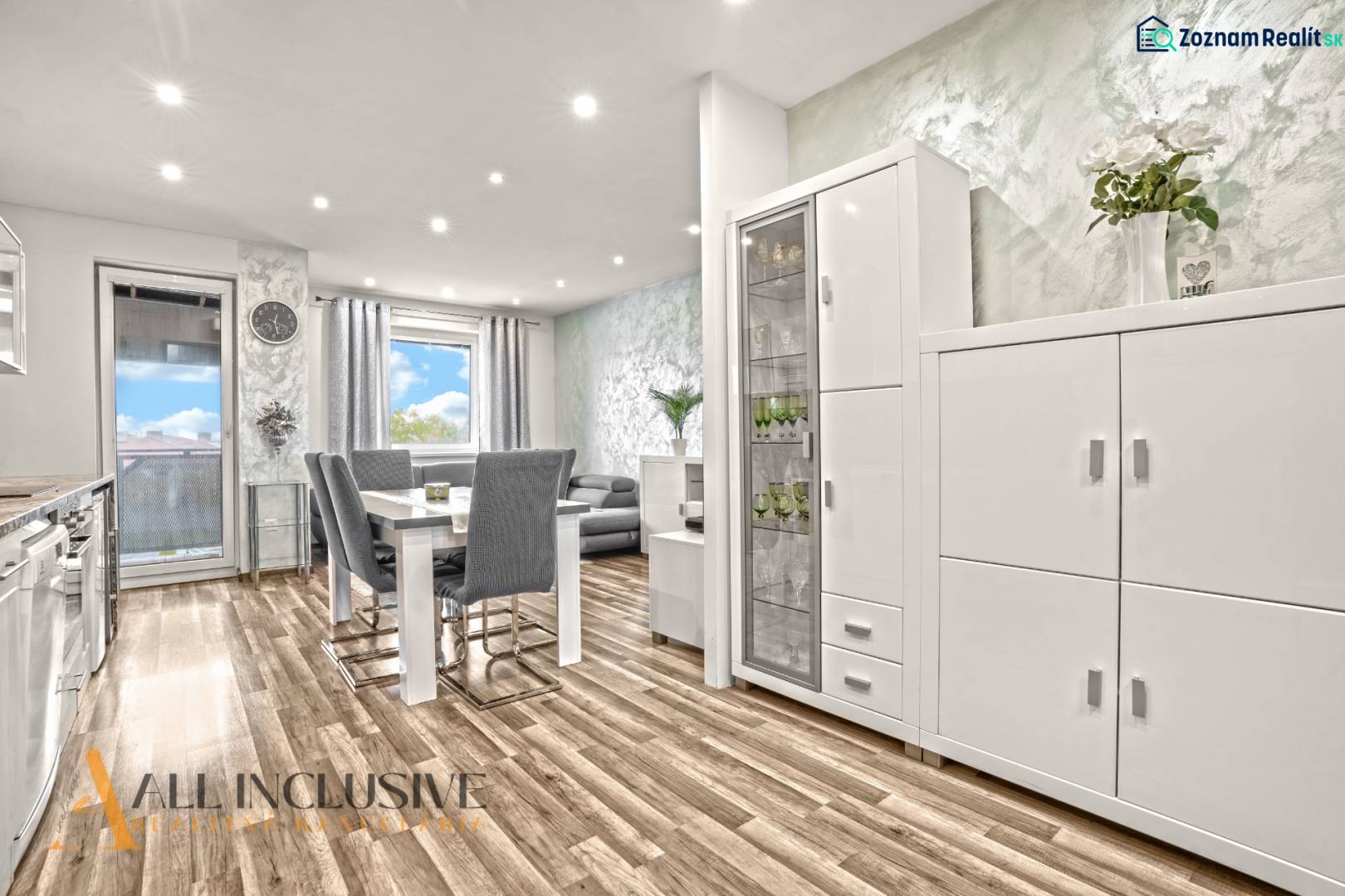 Světlý interiér 3-pokojového bytu s podlahou s dřevěným dekorem a bílým nábytkem.