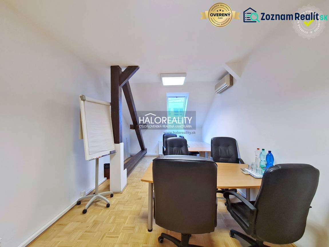 Kanceláře s podlahou s dřevěným dekorem, stůl, židle, flipchart, voda na stole.