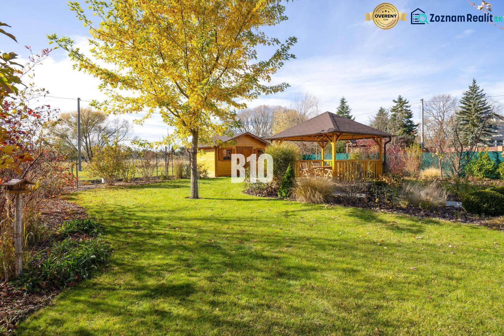 Zahrada rodinného domu v Bílkovej Humence s altánkem a zeleným trávníkem.