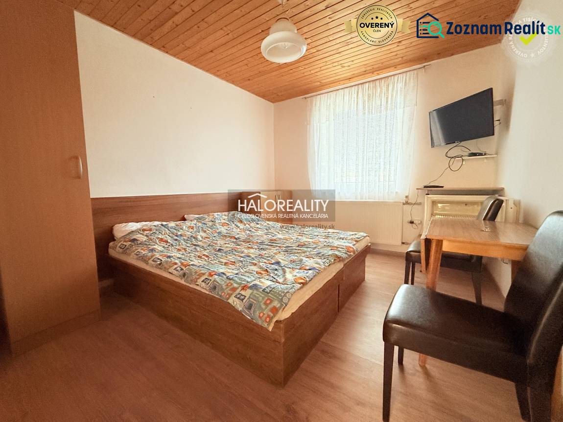 Pokoj v hotelech a penzionech s postelí, stolem a podlahou s dřevěným dekorem.