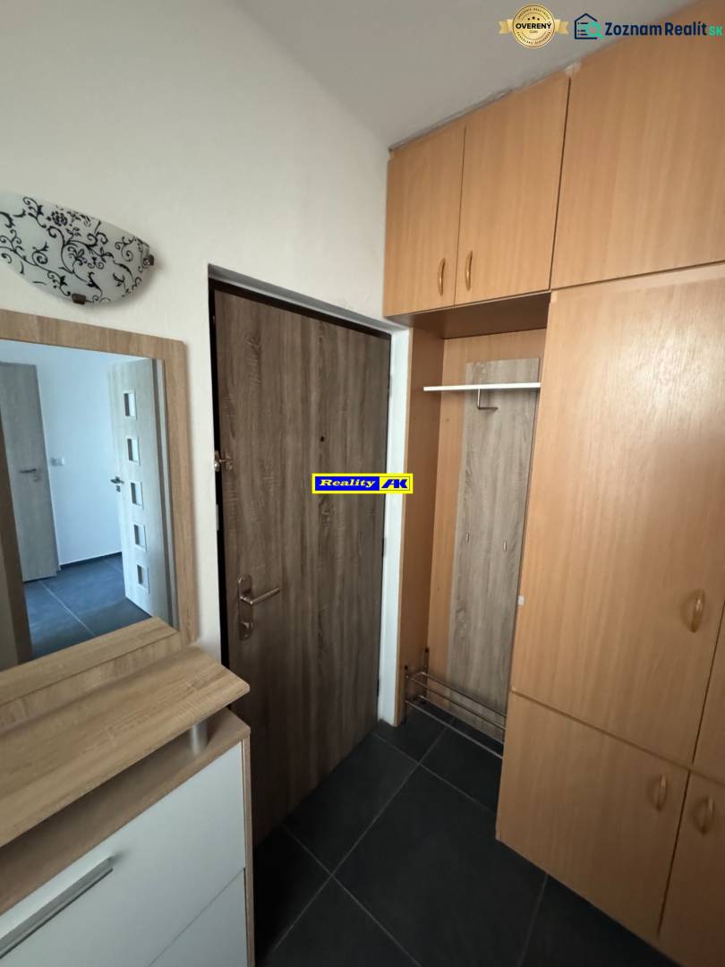 Vstupní hala s úložnými prostory v 3pokojovém bytě, podlaha s dřevěným dekorem.