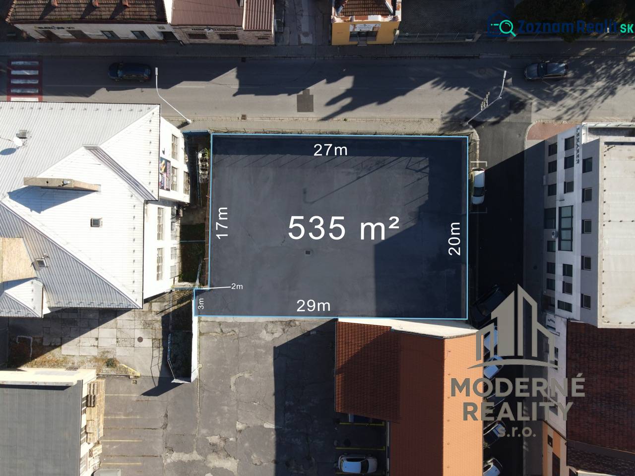 Letecký pohled na pozemek o rozloze 535 m² k bydlení v Nových Zámcích mezi budovami.