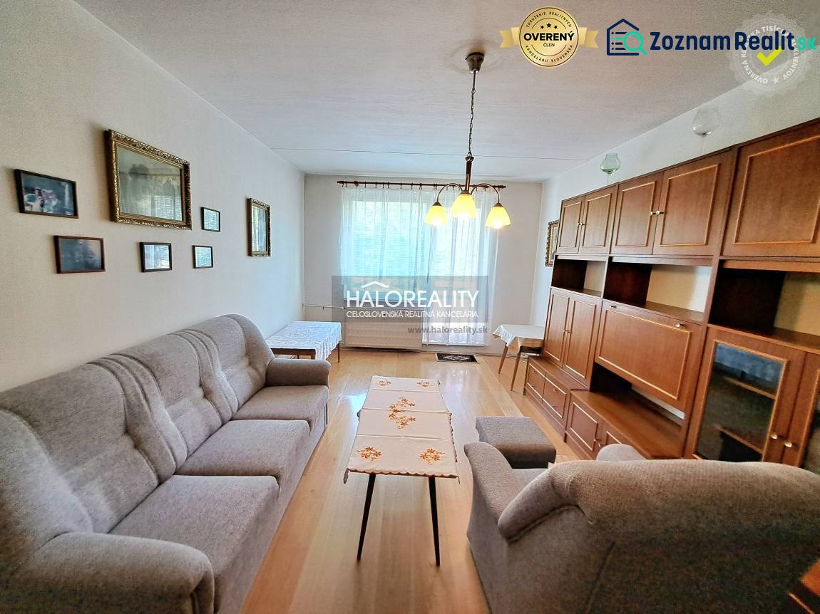 Obývací pokoj se světlem, podlahou s dřevěným dekorem a nábytkem ve 3-pokojovém bytě.