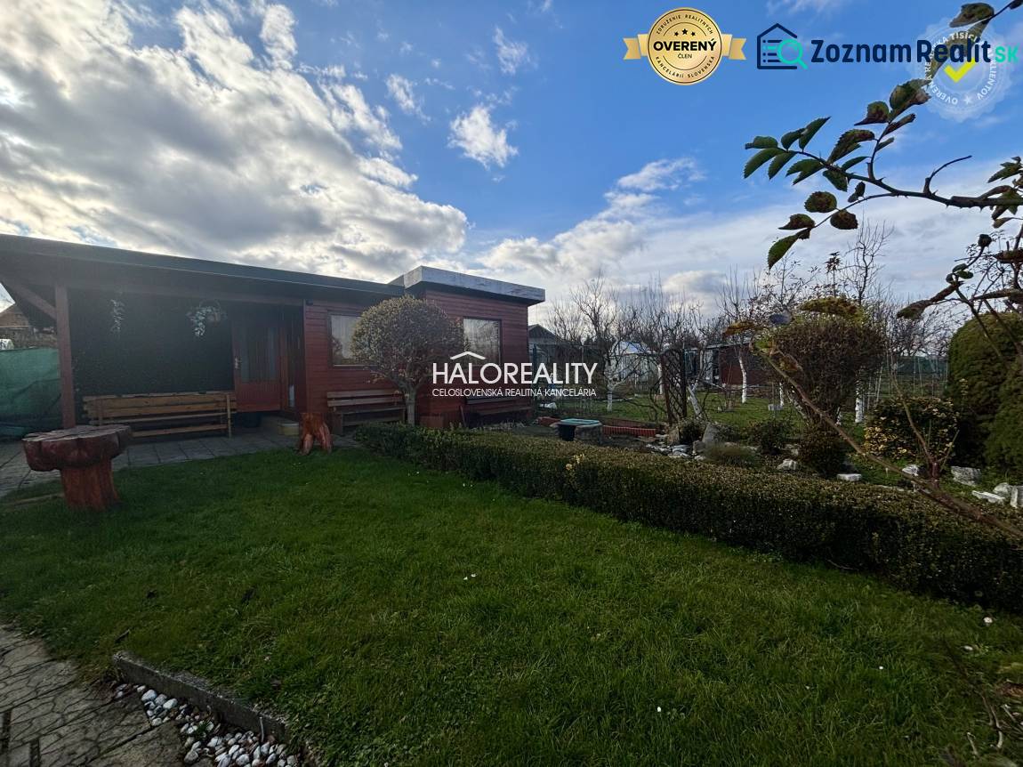 Dřevěný altán v zahradě ve Spišské Nové Vsi se zeleným trávníkem a zelení.