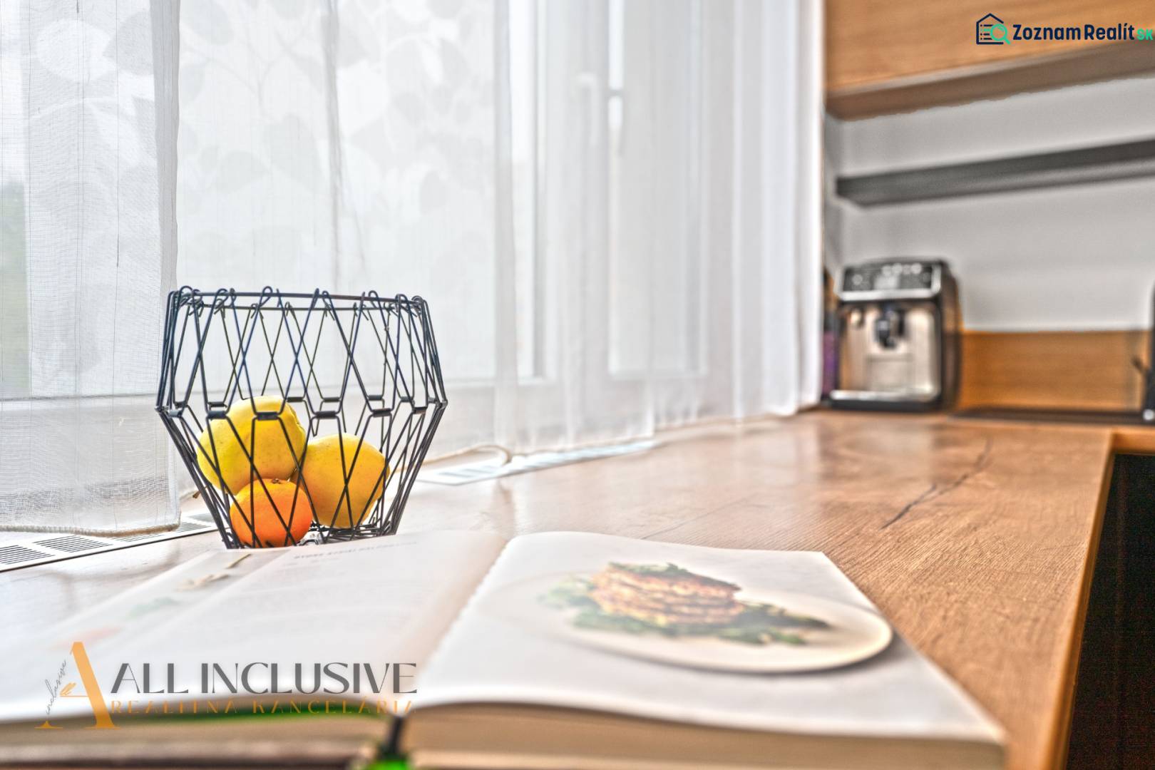 Otevřená kuchyně v 3-pokojovém bytě s dřevěným dekorem, miska s ovocem na stole.