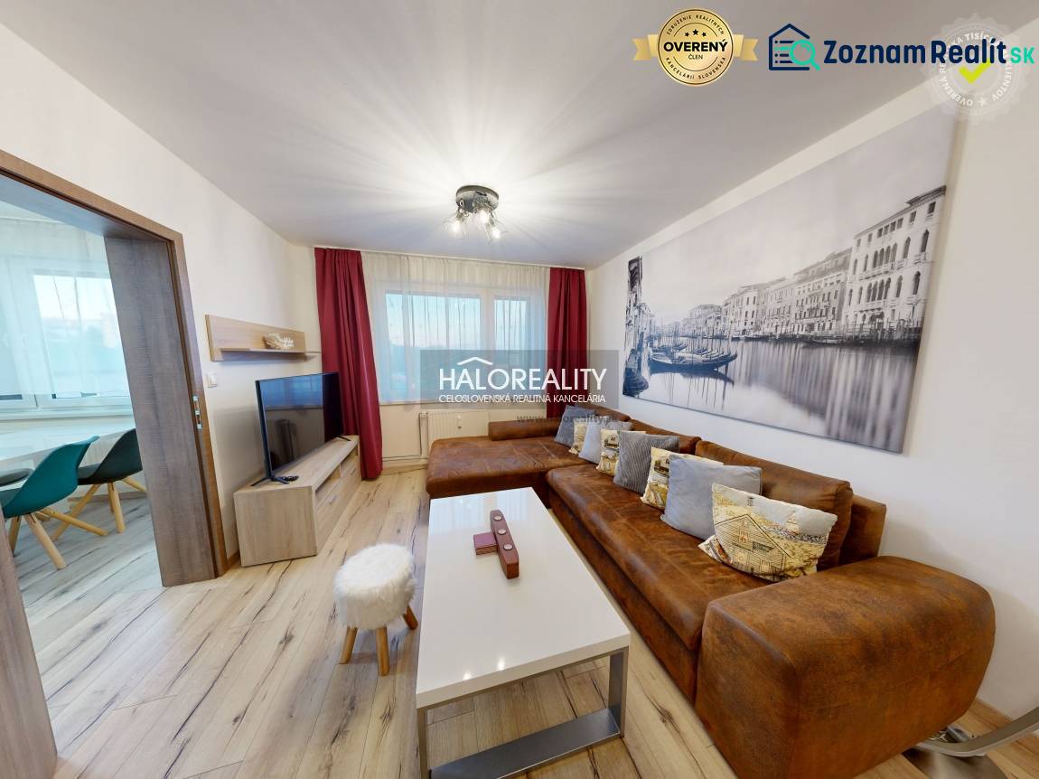 Obývací pokoj v 2-pokojovém bytě s hnědou sedačkou a podlahou s dřevěným dekorem.