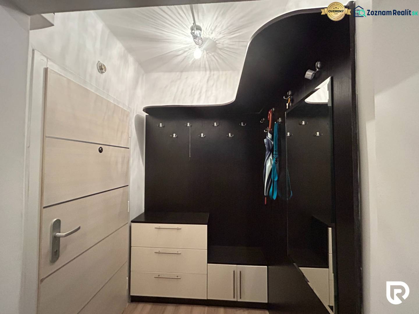 Vstupní hala s praktickým nábytkovým řešením v 1-pokojovém bytě s podlahou s dřevěným dekorem.