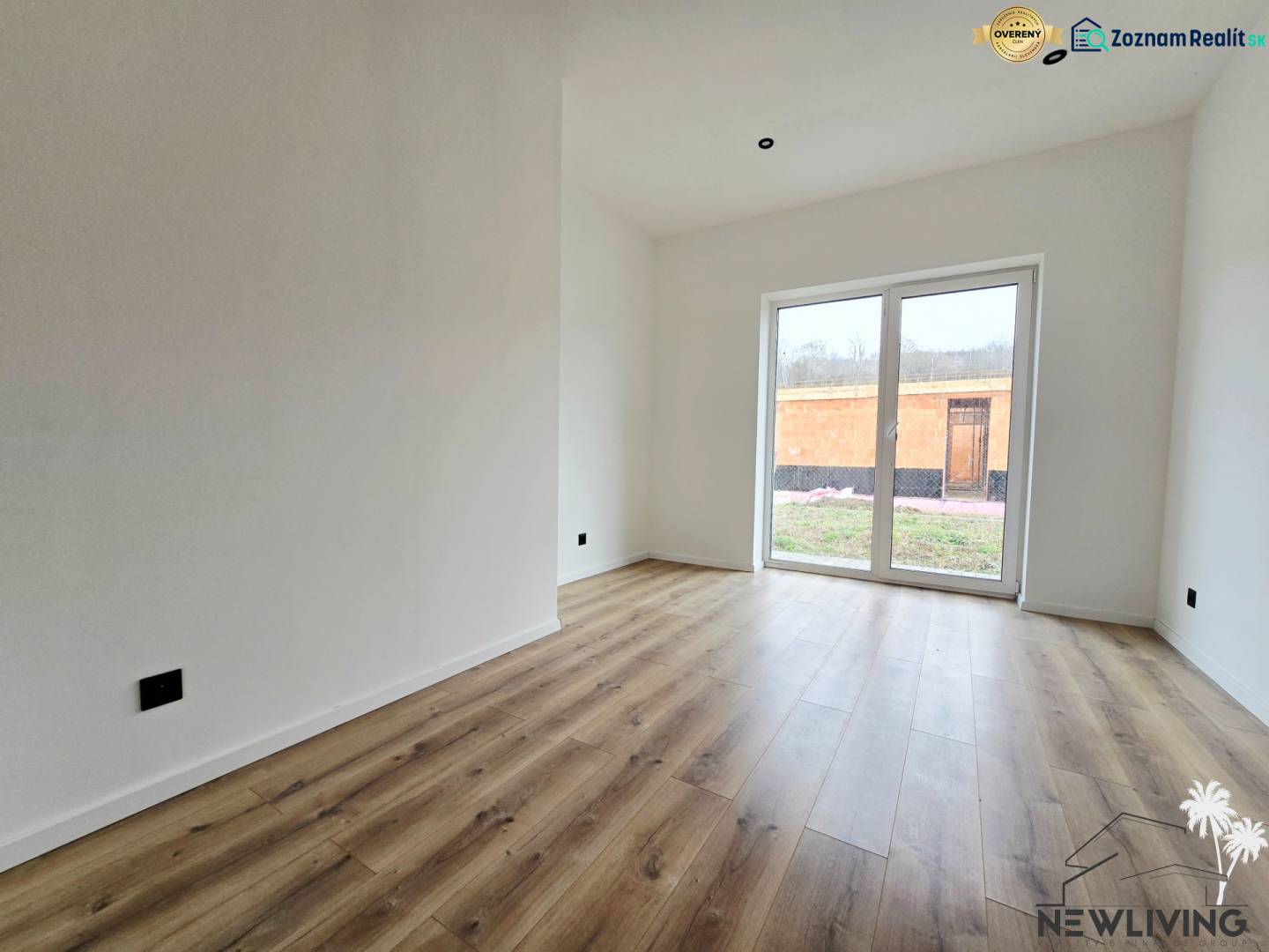 Rodinný dům s podlahou s dřevěným dekorem a velkými okny do zahrady.