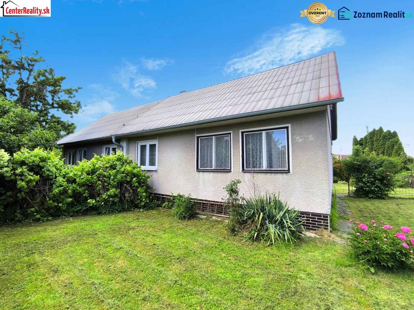 Rodinný dům v Novácích se zahradou, trávníkem a okrasnými keři.