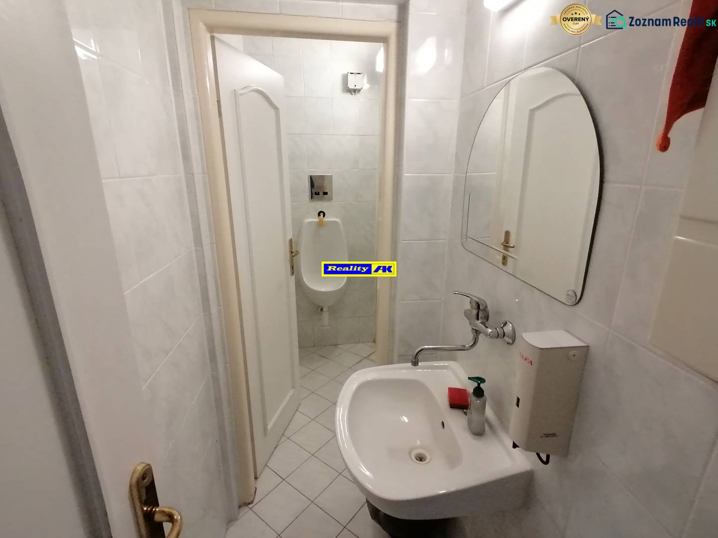 Malá koupelna s umyvadlem a pisoárem v kancelářích.