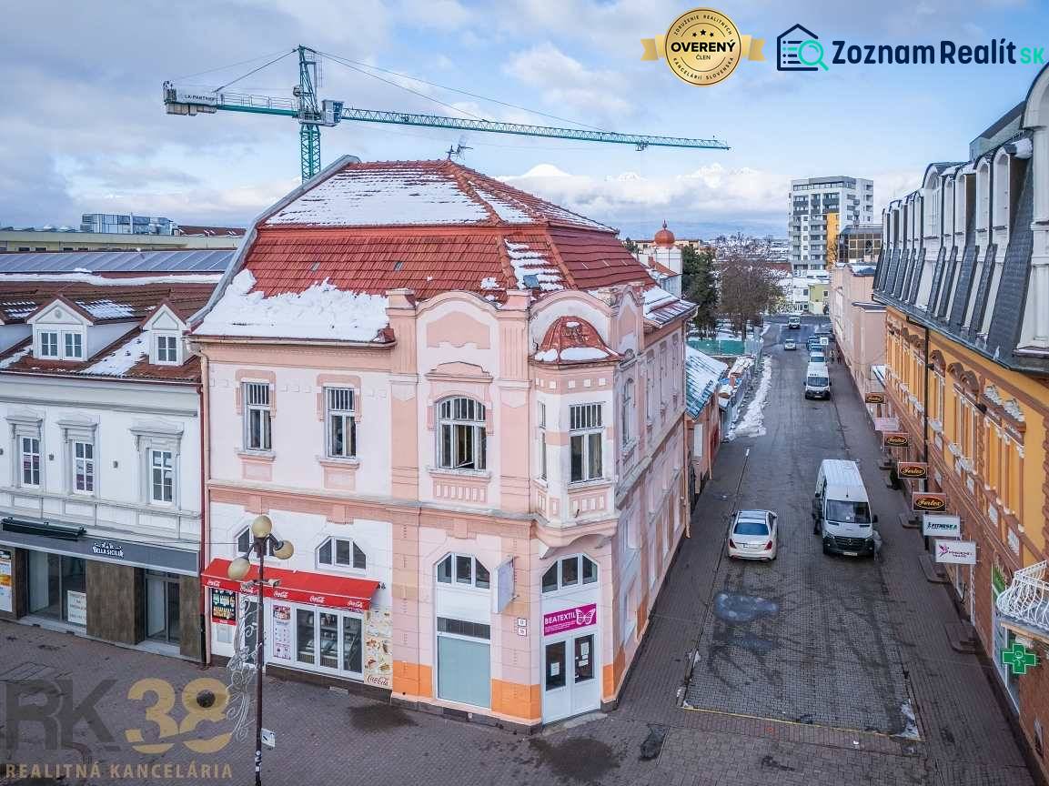 Budova ve městě Poprad s historickou architekturou a zasněženou střechou.