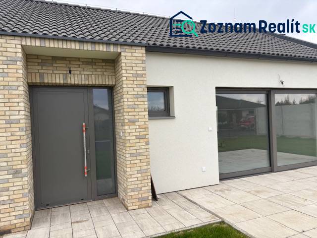 Rodinný dům na Fialkové v Tomášově s cihlovým obkladem a prostornými skleněnými dveřmi.