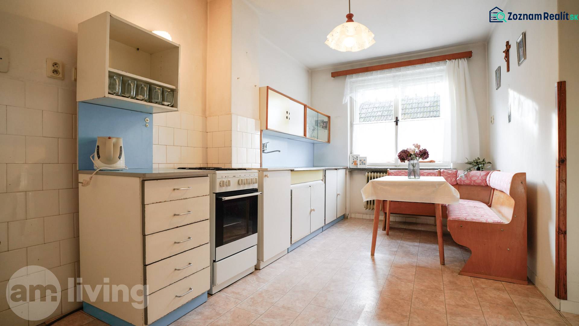 Kuchyně v rodinném domě s klasickým vybavením, rohovým sezením a oknem.