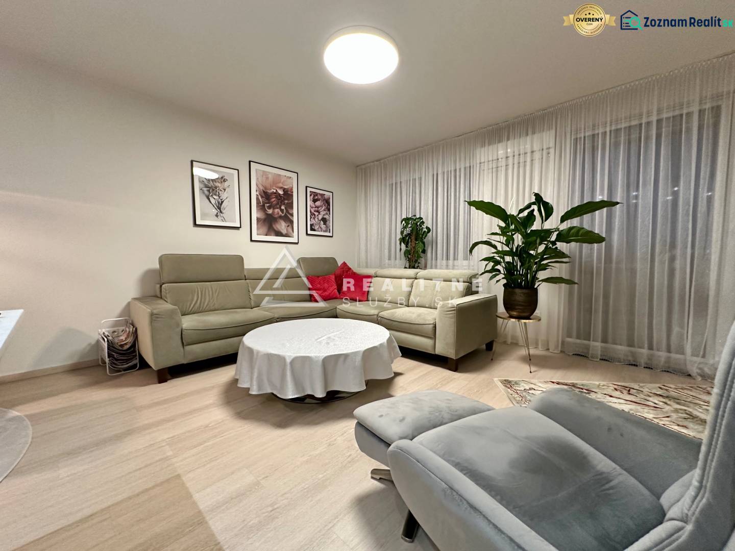 Obývací pokoj ve 4-pokojovém bytě s designovým nábytkem a rostlinami, podlaha s dřevěným dekorem.