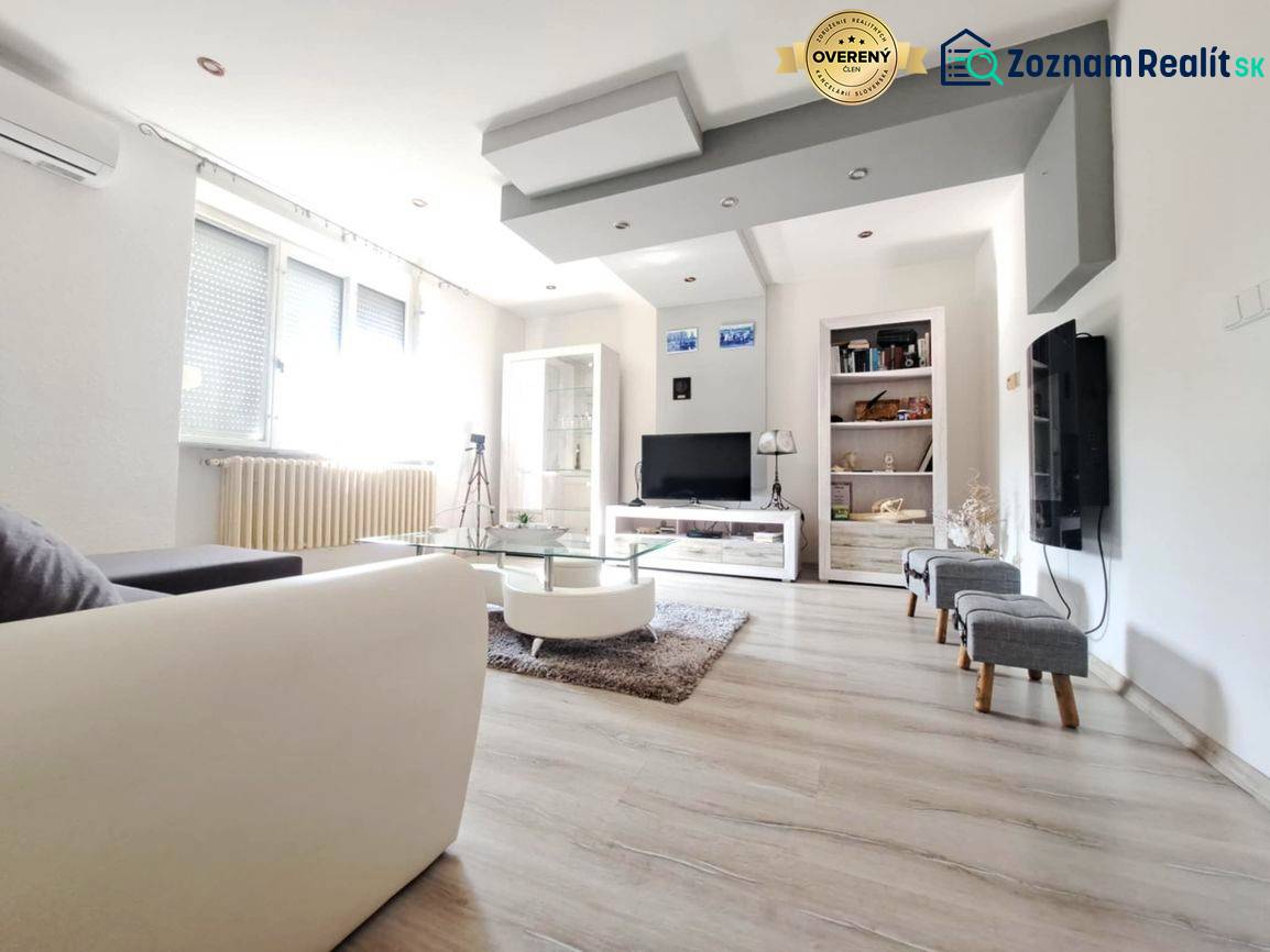 Obývací pokoj v rodinném domě s podlahou s dřevěným dekorem a pohovkou.