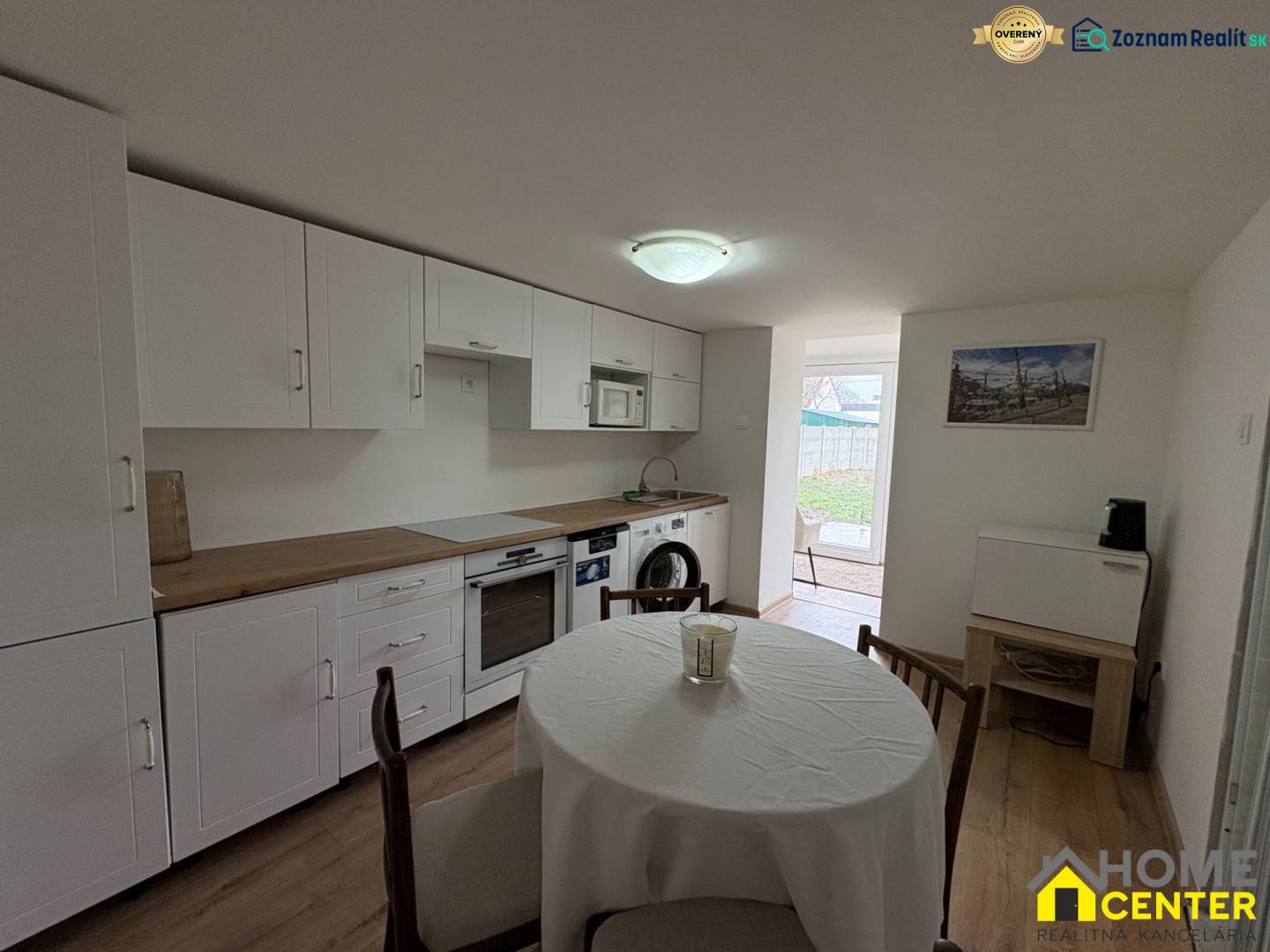 Kuchyně v 1-pokojovém bytě s podlahou s dřevěným dekorem a jídelním stolem.