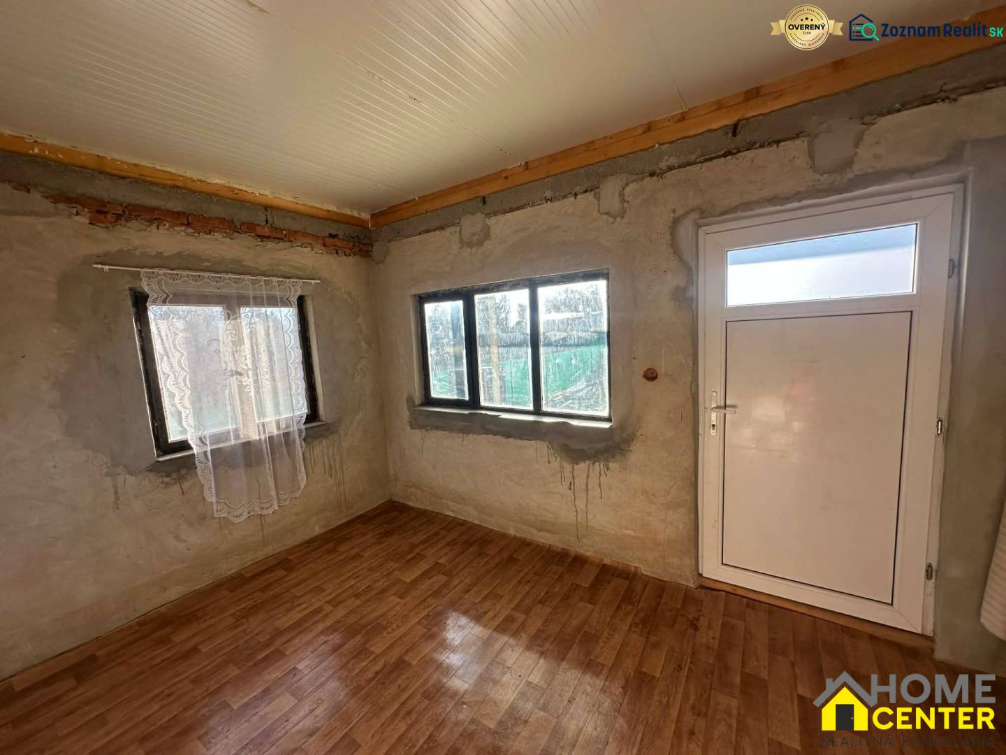 Interiér s podlahou s dřevěným dekorem a bílými dveřmi v části Zahrady.