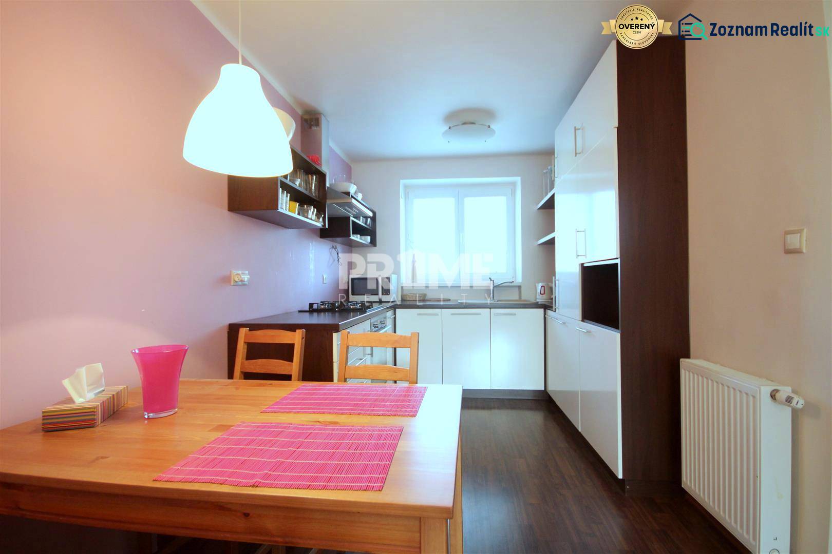 Kuchyně v 2-pokojovém bytě s podlahou s dřevěným dekorem a růžovými doplňky.