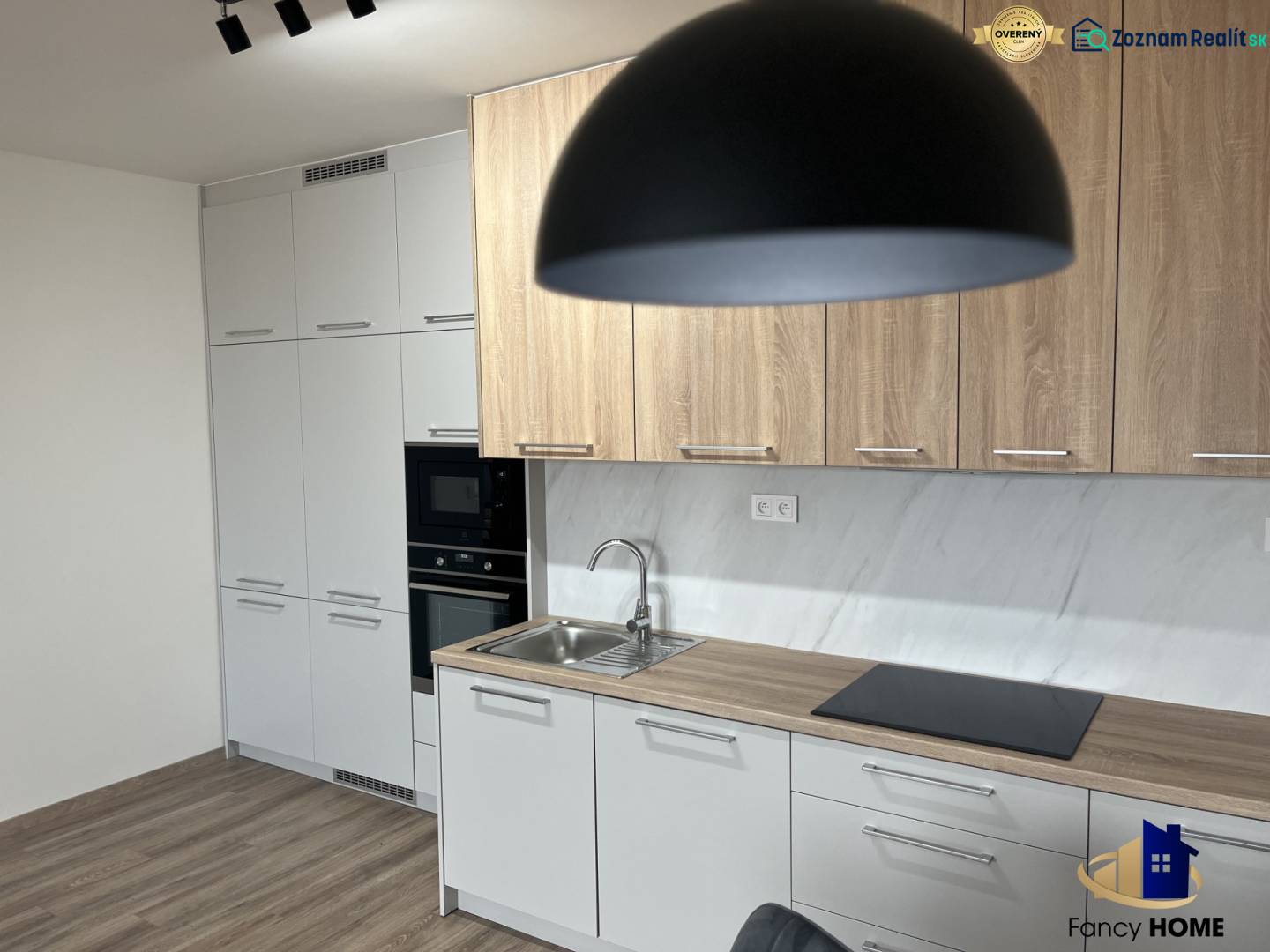 Kuchyně v 2-pokojovém bytě s podlahou s dřevěným dekorem a světlým nábytkem.