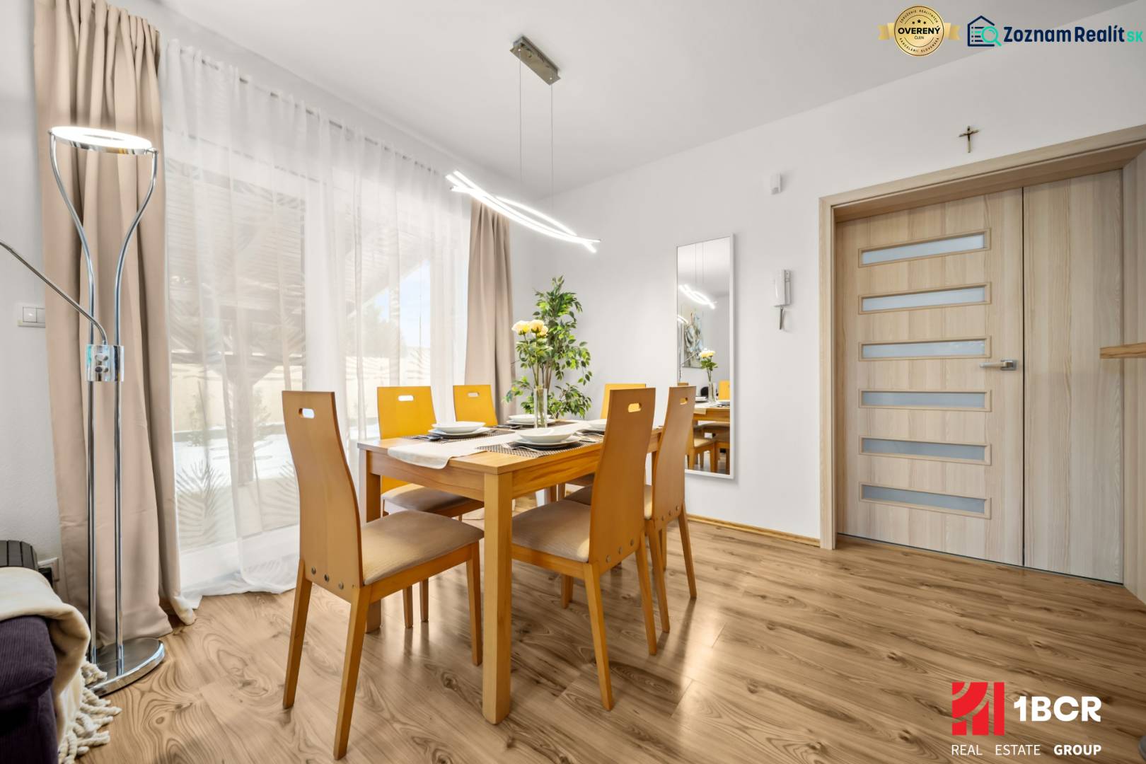 Jídelna s dřevěným stolem a podlahou s dřevěným dekorem v rodinném domě.