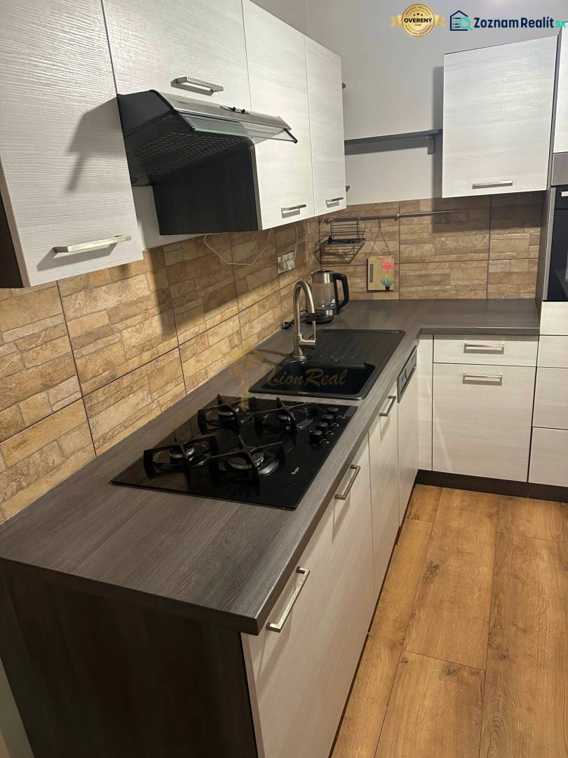 Kuchyně v 2-pokojovém bytě s plynovým sporákem, moderním obkladem a podlahou s dřevěným dekorem.