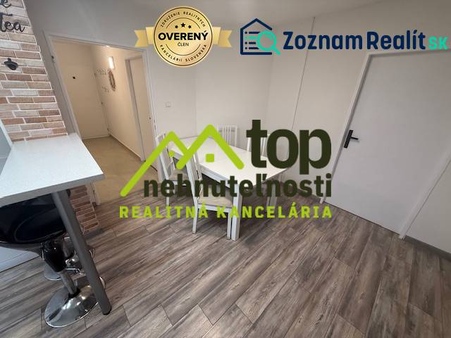 1-pokojový byt s podlahou s dřevěným dekorem a jídelním stolem.