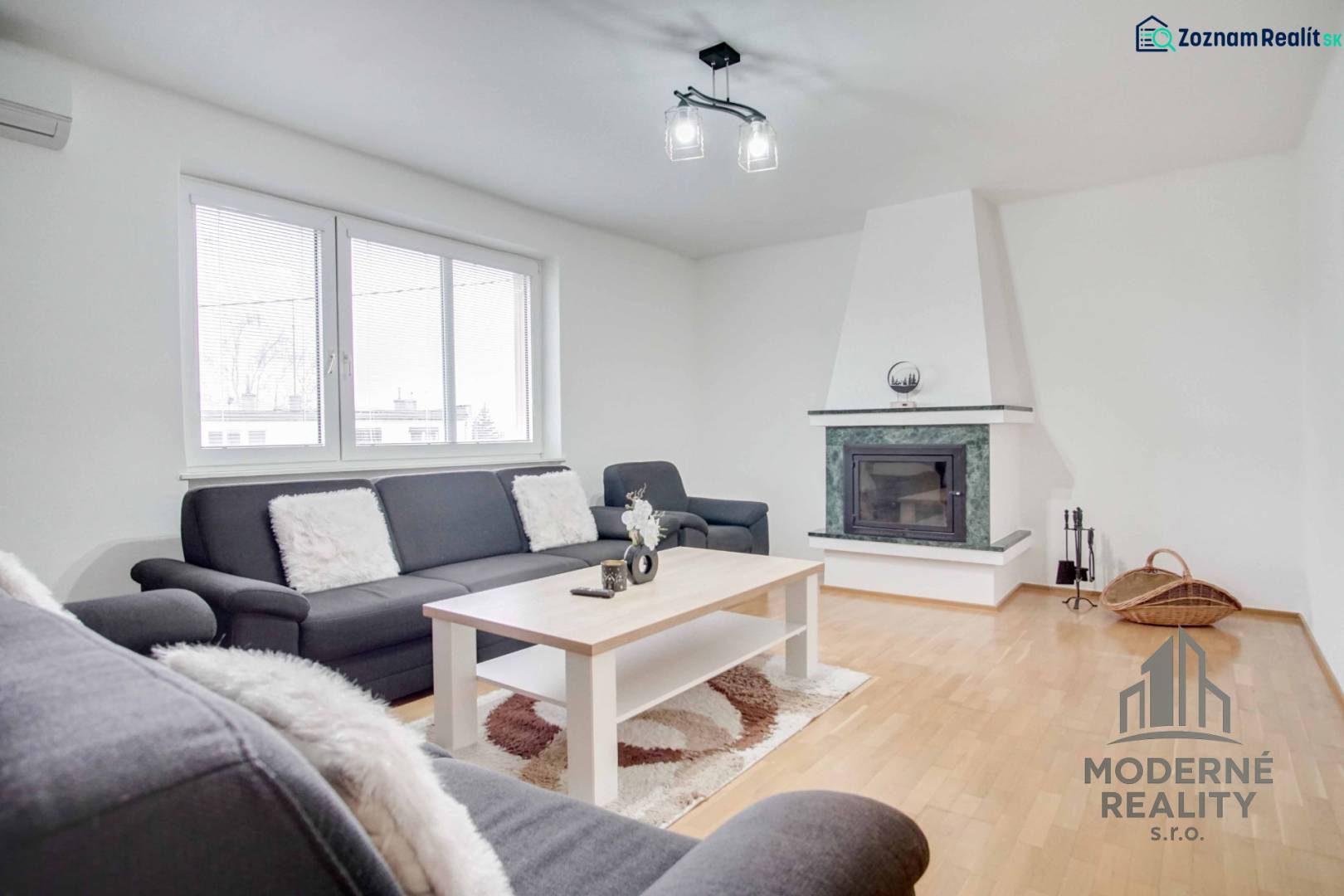 Obývací pokoj ve 4pokojovém bytě s krbem a podlahou s dřevěným dekorem.