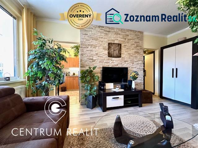 Obývací pokoj v 1-pokojovém bytě s rostlinami a podlahou s dřevěným dekorem.