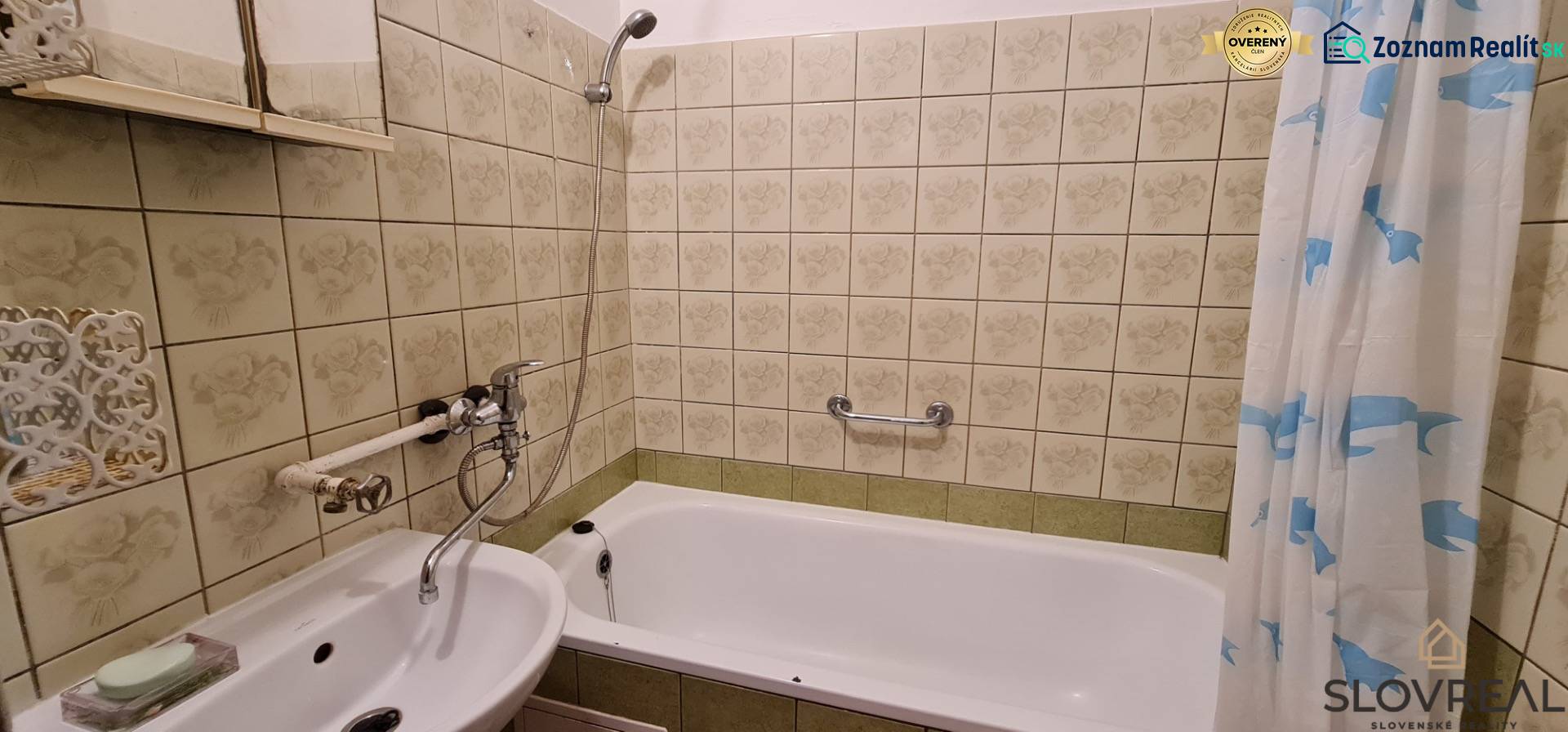 Koupelna se zrcadlem a vanou ve 3-pokojovém bytě, obložená dekorativními dlaždicemi.