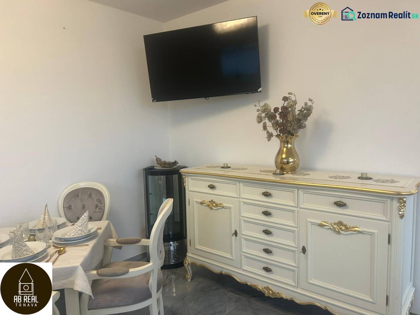 Elegantně zařízený interiér gastro prostor s televizorem na stěně a zdobeným nábytkem.