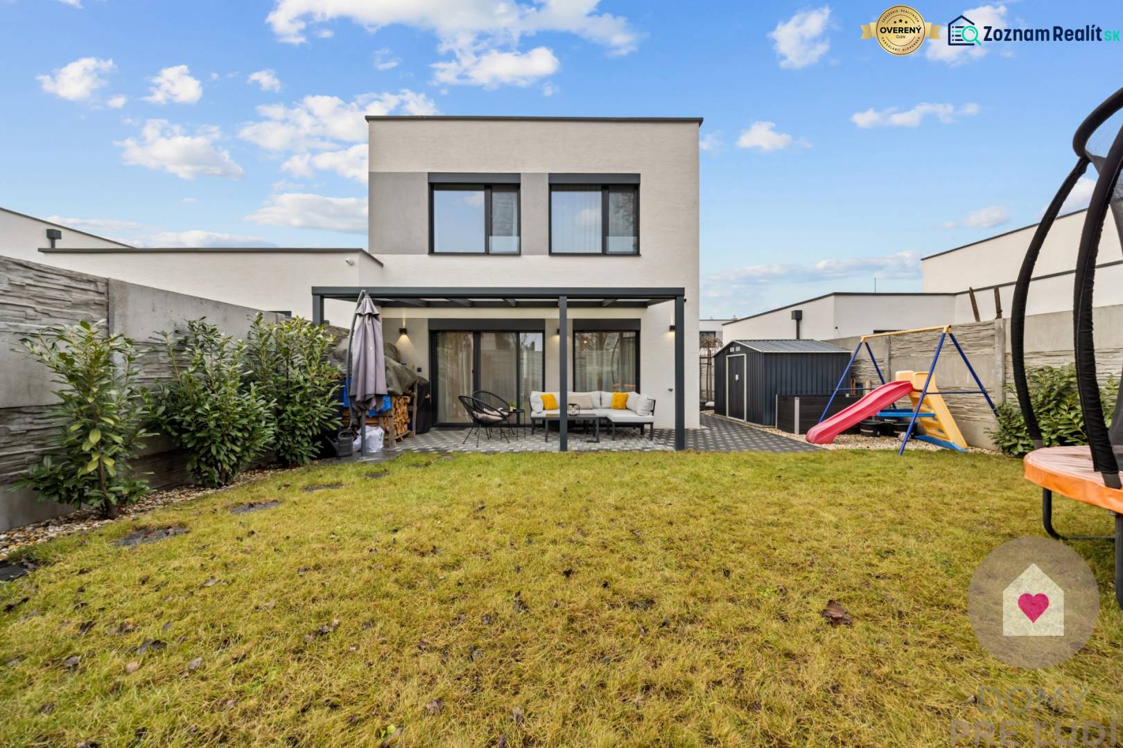 Zahrada 4pokojového bytu na Topolové ulici v Rovince s trávníkem a dětským hřištěm.