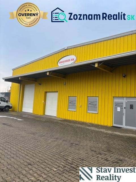 Žlutá budova skladu a haly na Polní cestě v Senci se vstupními branami.