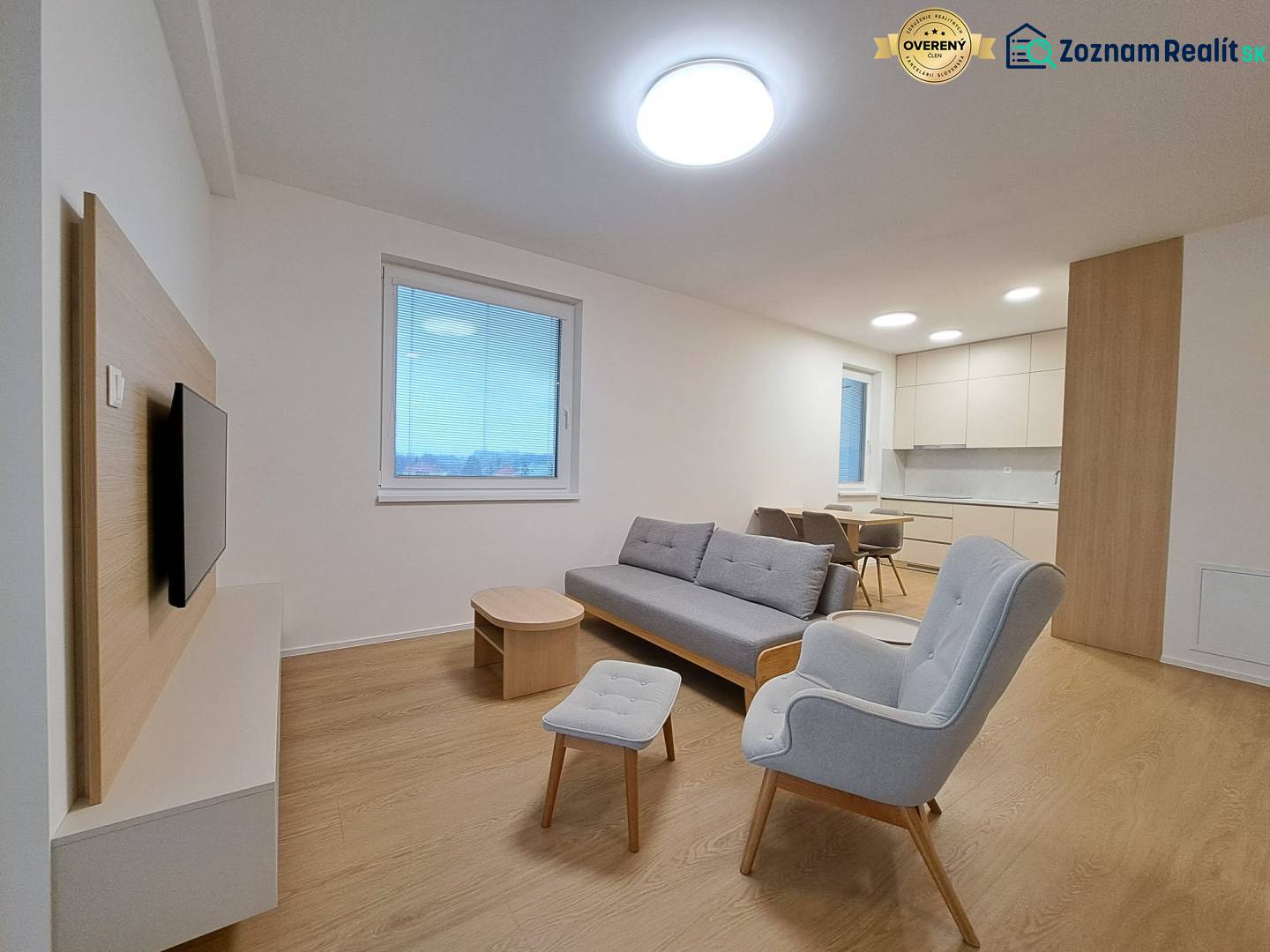 Obývací pokoj v 2-pokojovém bytě s podlahou s dřevěným dekorem a pohodlným sezením.