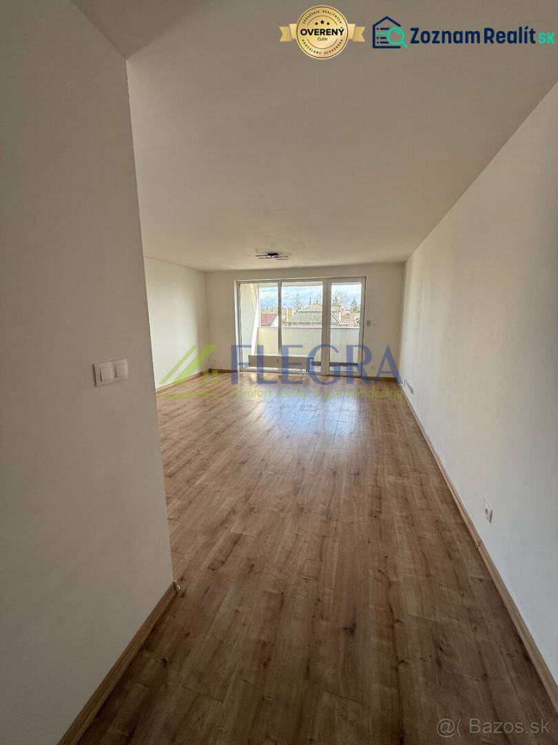 Světlý obývací pokoj s podlahou s dřevěným dekorem v 2pokojovém bytě.