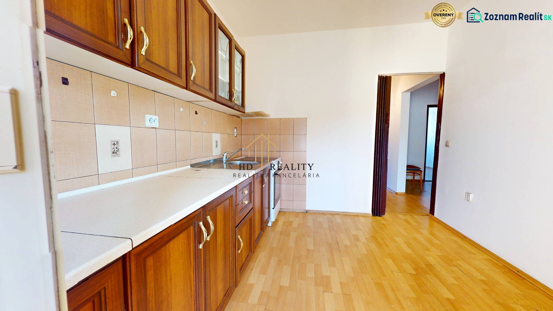 Kuchyně v 3-pokojovém bytě s podlahou s dřevěným dekorem a dřevěnými skříňkami.