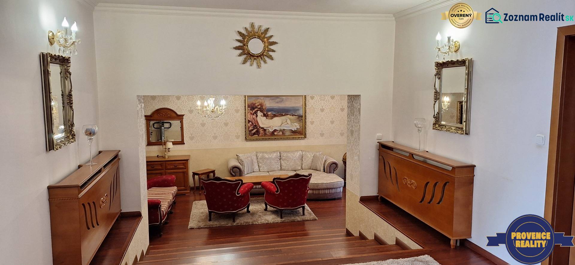 Luxusní interiér rodinného domu s dřevěným dekorem, pohovkou a uměleckými díly na stěnách.