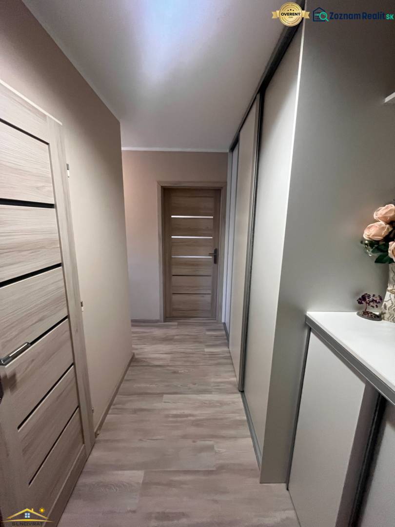 Chodba v 3-pokojovém bytě s podlahou s dřevěným dekorem.